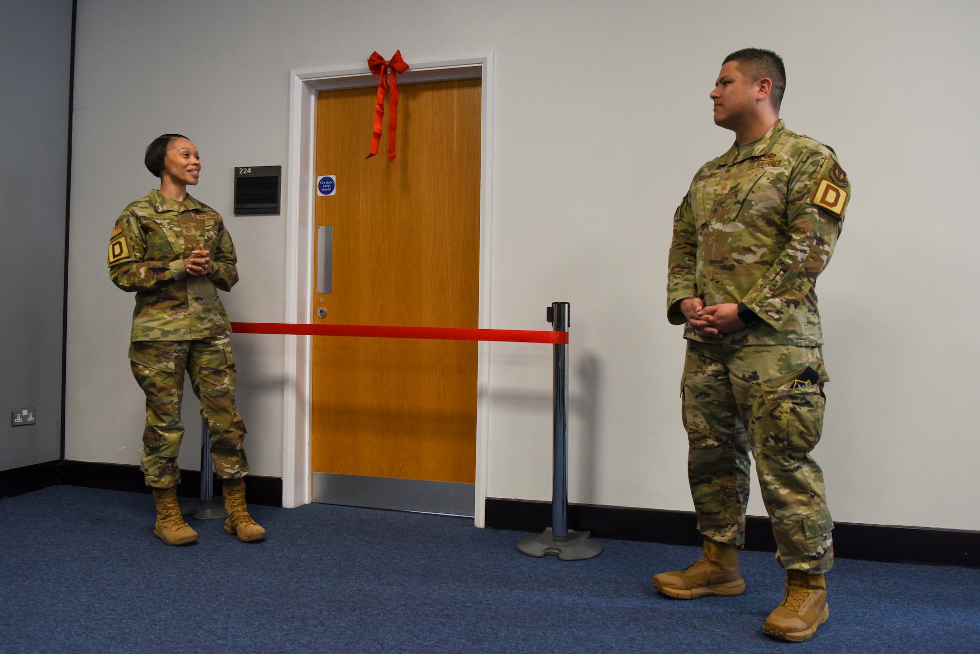 U.S. Air Force Chief Master Sgt. Tiffany Griego, left, 100th Air Refueling Wing command chief, thanks Master Sgt. Justin Villalpando, 100th Logistics Readiness Squadron first sergeant, for leading the charge on establishing the newly opened Key Support Liaison Hub during the ribbon-cutting ceremony at RAF Mildenhall, England, March 19, 2025.