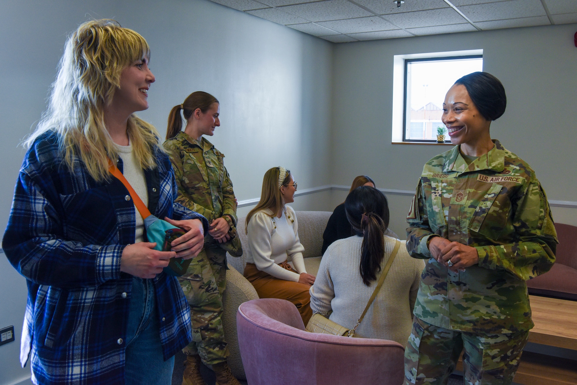 U.S. Air Force Chief Master Sgt. Tiffany Griego, right, 100th Air Refueling Wing command chief, speaks with an attendee to the Key Support Liaison Hub opening ceremony at RAF Mildenhall, England, March 19, 2025.