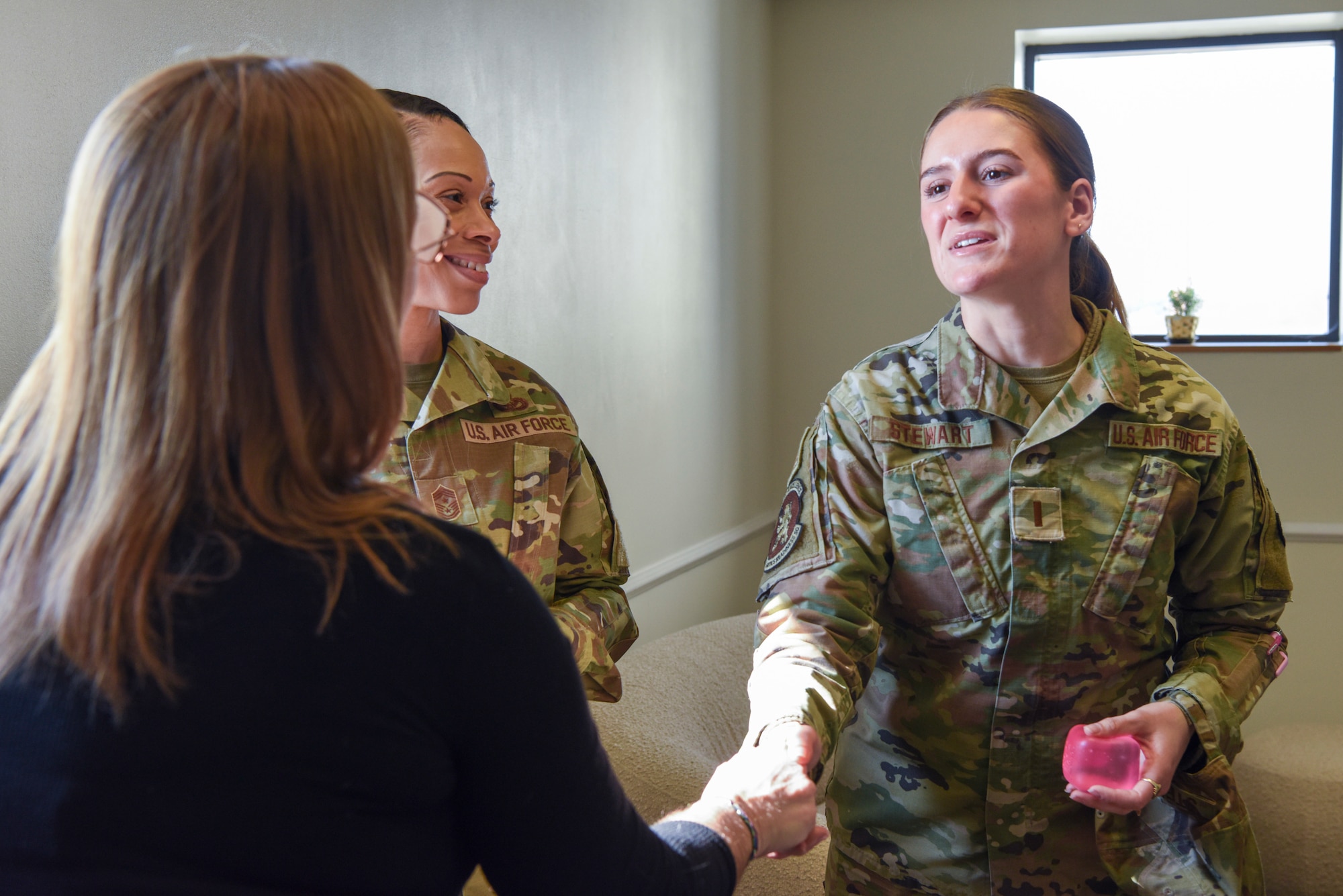 U.S. Air Force 2nd Lt. Claire Stewart, right, 100th Logistics Readiness Squadron Vehicle Management officer in charge and key support liaison, shakes hands with another KSL during the KSL Hub opening at RAF Mildenhall, England, March 19, 2025.
