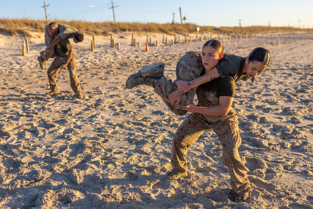 U.S. Marines with 2nd Marine Logistics Group conduct buddy squats during a beach workout as part of Corporals Course on Marine Corps Base Camp Lejeune, North Carolina, March 19, 2025. Corporals Course is designed to provide Marines with the knowledge and skills to become successful small-unit leaders in the U.S. Marine Corps. (U.S. Marine Corps photo by Cpl. Christian Salazar)