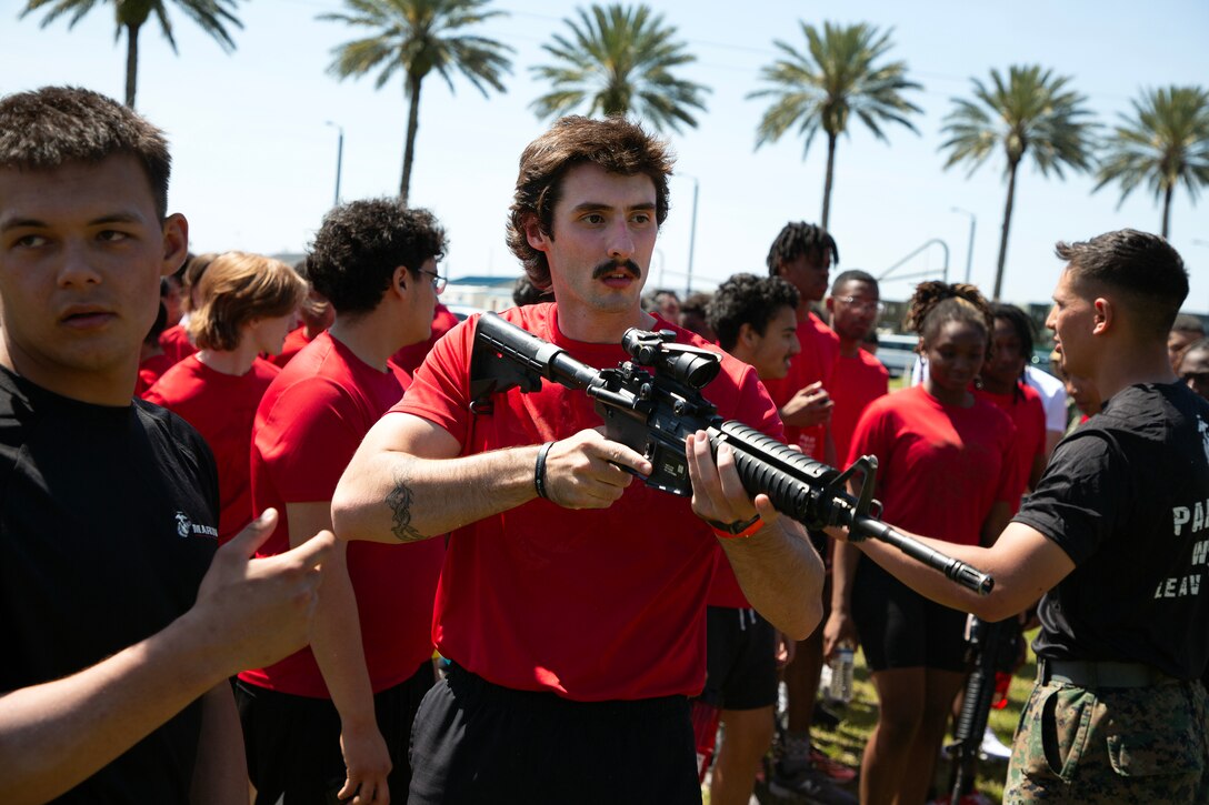 Garrett Payne, 19, of Ocala, Florida, holds an M4 rifle during a Marine Corps Recruiting Station Jacksonville pool function March 22 at Marine Corps Support Facility Blount Island in Jacksonville, Florida. Roughly 275 young men and women from across Florida and Georgia participated in the annual event, designed to assess the physical and mental readiness of future recruits before they ship to boot camp.