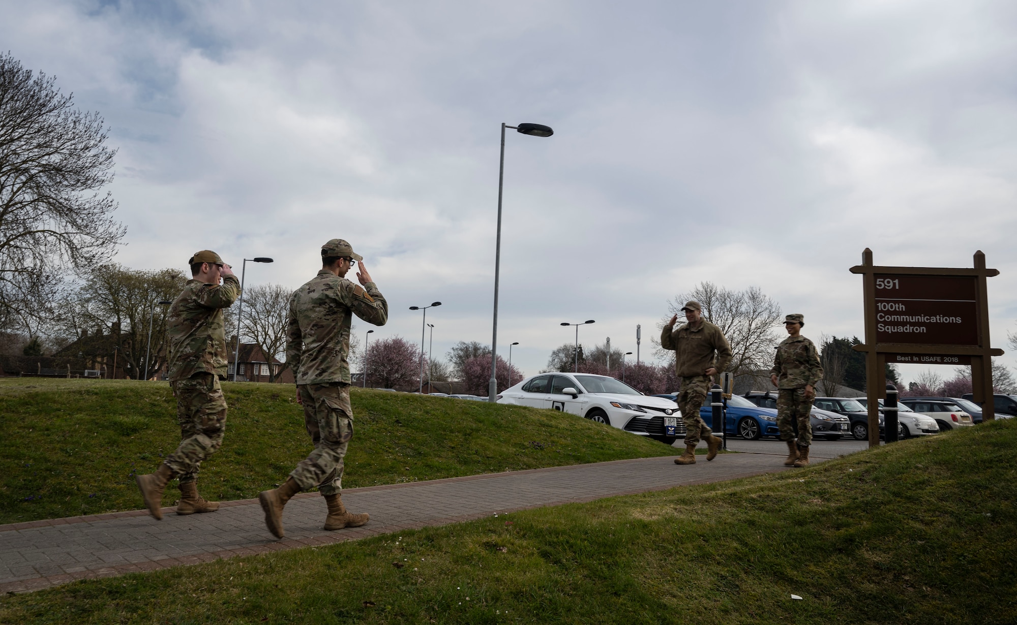 U.S. Airmen assigned to the 100th Communications Squadron render a salute to the 100th Air Refueling Wing command team as they greet them at RAF Mildenhall, England, March 21, 2025.