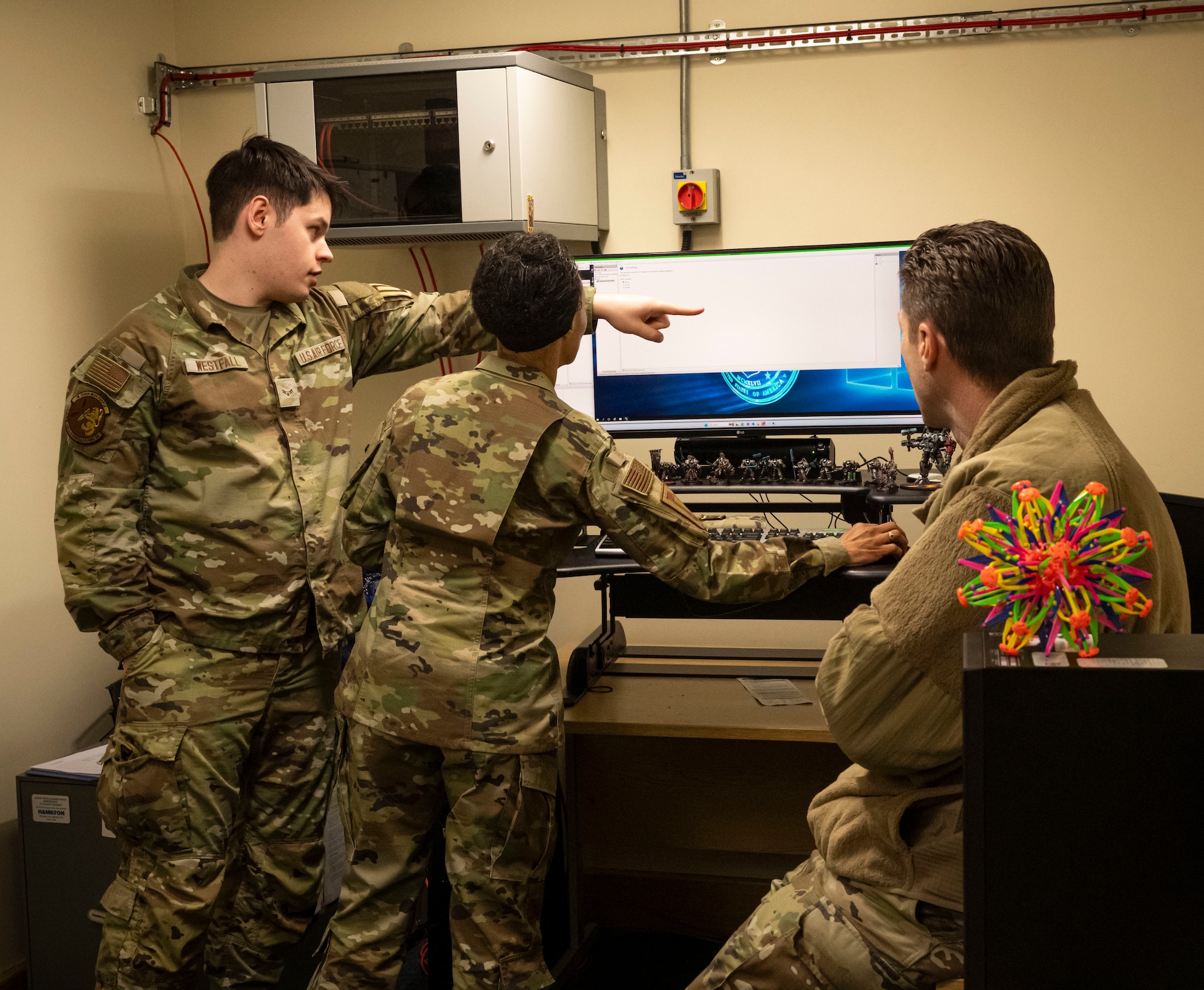 U.S. Air Force Airman 1st Class Michael Westfall, left, 100th Communications Squadron cyber system technician, guides Chief Master Sgt. Tiffany Griego, 100th Air Refueling Wing command chief, through the operations to create a new server at RAF Mildenhall, England, March 21, 2025.