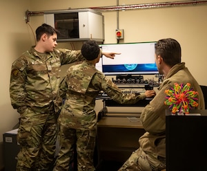 U.S. Air Force Airman 1st Class Michael Westfall, left, 100th Communications Squadron cyber system technician, guides Chief Master Sgt. Tiffany Griego, 100th Air Refueling Wing command chief, through the operations to create a new server at RAF Mildenhall, England, March 21, 2025.