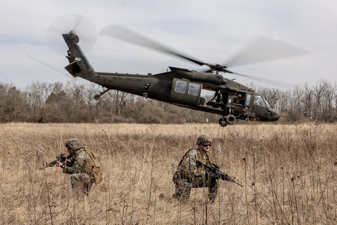 U.S. Marine Corps Sgt. Kyle Dykins, a transmissions system operator with Detachment, Communication Company, 14th Marine Regiment, 4th Marine Division, scans the training area after an extraction via a UH-60 Black Hawk during a joint communications exercise with the 38th Combat Aviation Brigade, Indiana National Guard in Camp Atterbury, Edinburgh, Indiana, March 14, 2025.