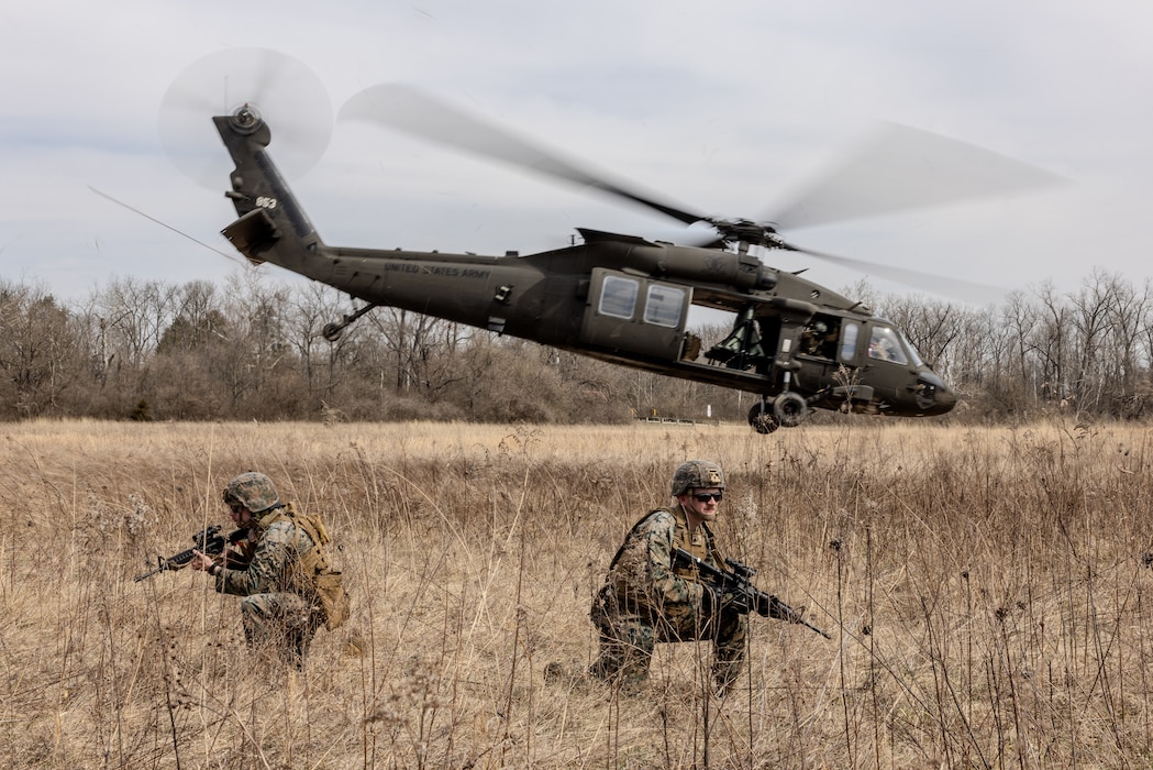 U.S. Marine Corps Sgt. Kyle Dykins, a transmissions system operator with Detachment, Communication Company, 14th Marine Regiment, 4th Marine Division, scans the training area after an extraction via a UH-60 Black Hawk during a joint communications exercise with the 38th Combat Aviation Brigade, Indiana National Guard in Camp Atterbury, Edinburgh, Indiana, March 14, 2025.