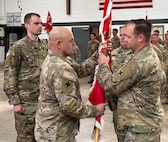 Lt. Col. Garrett Dean, right, outgoing commander of 766th Brigade Engineer Battalion, relinquishes command by passing the battalion’s guidon to Col. Seth Hible, Commander of the 33rd Infantry Brigade Combat Team, during a change of command ceremony March 16 at Marseilles Training Center.
