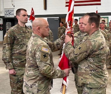 Lt. Col. Garrett Dean, right, outgoing commander of 766th Brigade Engineer Battalion, relinquishes command by passing the battalion’s guidon to Col. Seth Hible, Commander of the 33rd Infantry Brigade Combat Team, during a change of command ceremony March 16 at Marseilles Training Center.