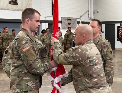 Maj. Timothy Heagney, left, incoming commander of the 766th Brigade Engineer Battalion, assumes command as Col. Seth Hible, Commander of the 33rd Infantry Brigade Combat Team, passes the battalion’s guidon during a change of command ceremony March 15 at Marseilles Training Center.