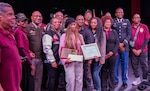 Aaliyah Johnson, center, the 2025 recipient of the Captain Walter H. Dyett award, is joined by her parents, members of the 8th Infantry Association, school officials from the Walter H. Dyett High School for Fine Arts in Chicago, and Maj. Gen. Rodney Boyd, The Adjutant General of Illinois and Commander of the Illinois National Guard, during the third annual Captain Walter H. Dyett award ceremony March 19.