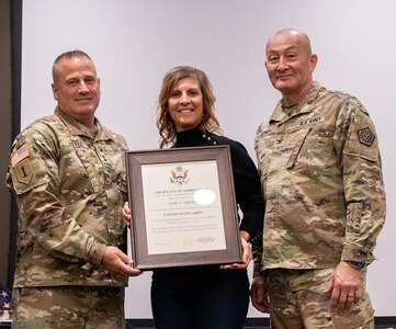 Maj. Gen. Eric Little, left, presents Lori Smith, wife of Col. Eric Smith, a certificate of appreciation for her support of Smith’s 36 years of military service during a retirement ceremony March 21 at the Illinois Military Academy on Camp Lincoln, Springfield.