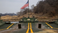 U.S. Army Spc. John Alvarado (left) and Pvt. 2nd Class Andrew MacIntyre, assigned to the 814th Multi-Role Bridge Company, 11th Engineer Battalion, 2nd Infantry Division Sustainment Brigade, 2nd Infantry Division, use a Bridge Erection Boat (BEB) to assemble an Improved Ribbon Bridge (IRB) while conducting joint wet gap training during Freedom Shield 25 at Yeoncheon-gun, Republic of Korea, on March 20, 2025.