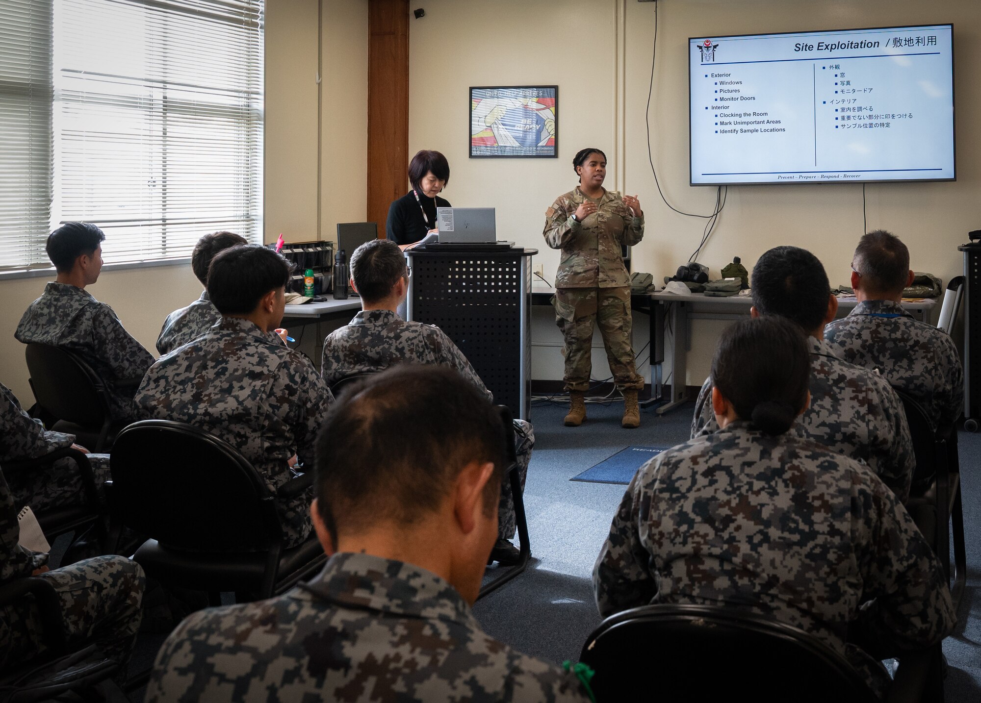 A U.S. Air Force service member gives a speech to a group of Japanese Air Self-Defense Force members.