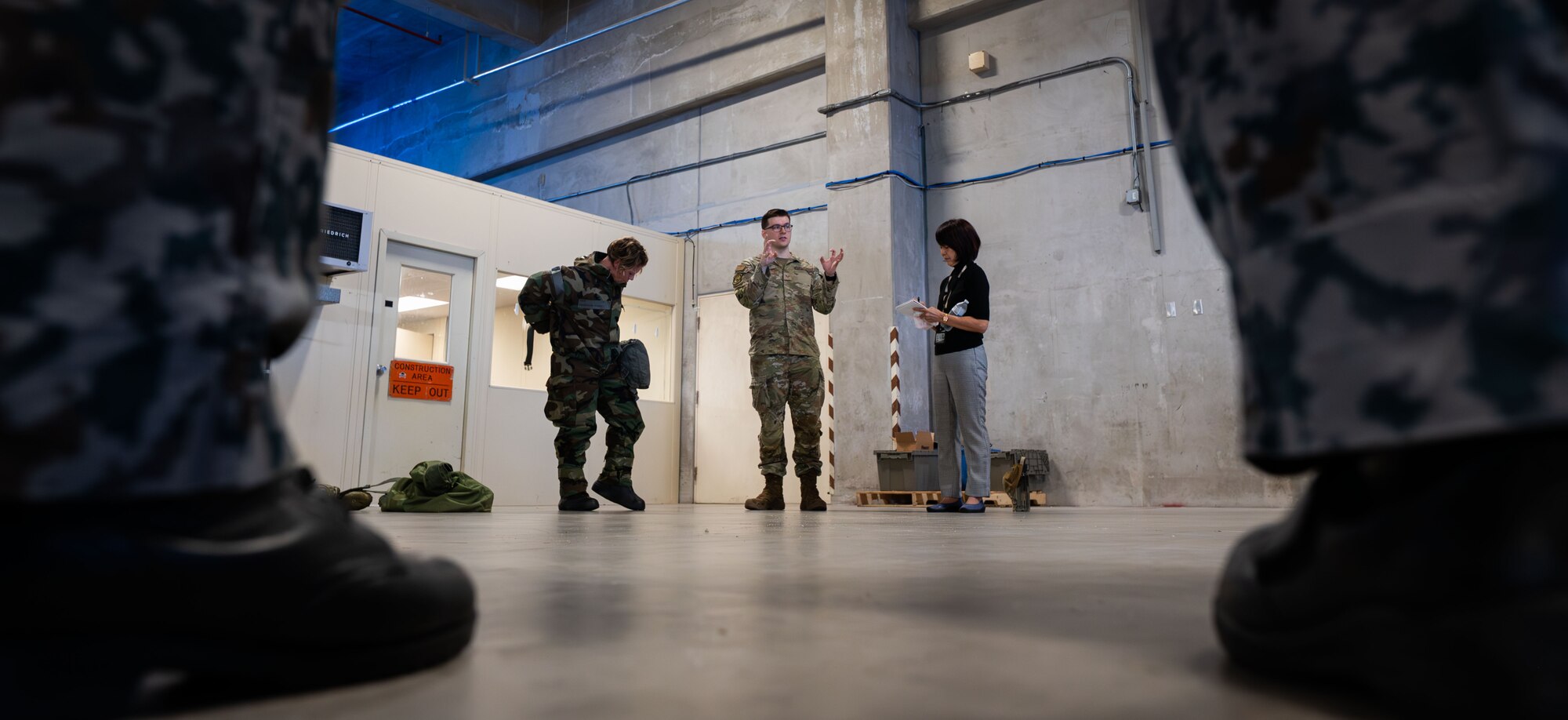 Japanese Air Self-Defense force members watch U.S. service members don chem gear.