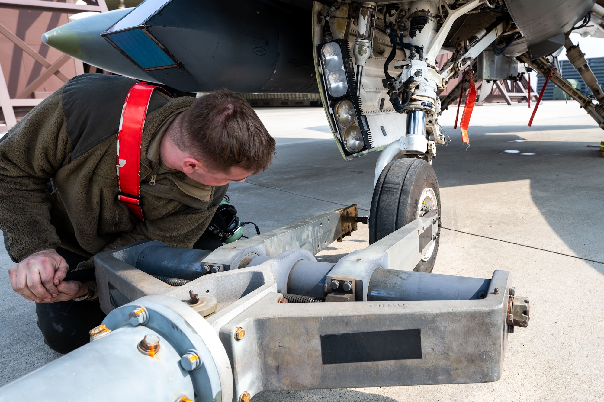 A U.S. Airman assigned to the 51st Fighter Wing secures a tow bar to the wheel of an F-16 Fighting Falcon aircraft at Suwon Air Base, South Korea, March 7, 2025. The 51st Fighter Wing and 11th Air Task Force worked together to land, refuel and store the aircraft in preparation for Freedom Shield 25. (U.S. Air Force photo by Senior Airman Jasmyne Bridgers-Matos)