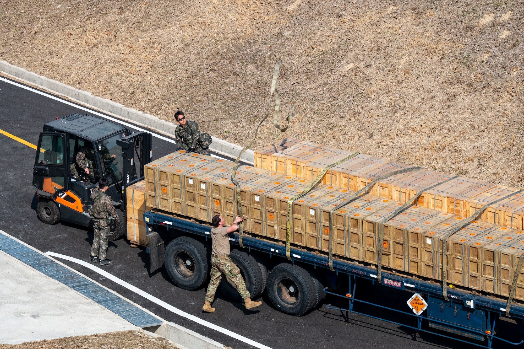 U.S. 11th Air Task Force Airmen and members of the Republic of Korea Air Force secure munitions onto a vehicle in support of Freedom Shield 25 at Suwon Air Base, South Korea, March 11, 2025. 11 ATF Airmen assisted ROKAF service members with the movement of munitions in order to guarantee safe handling, efficient organization and quick accessibility for potential operations. (U.S. Air Force photo by Senior Airman Jasmyne Bridgers-Matos)