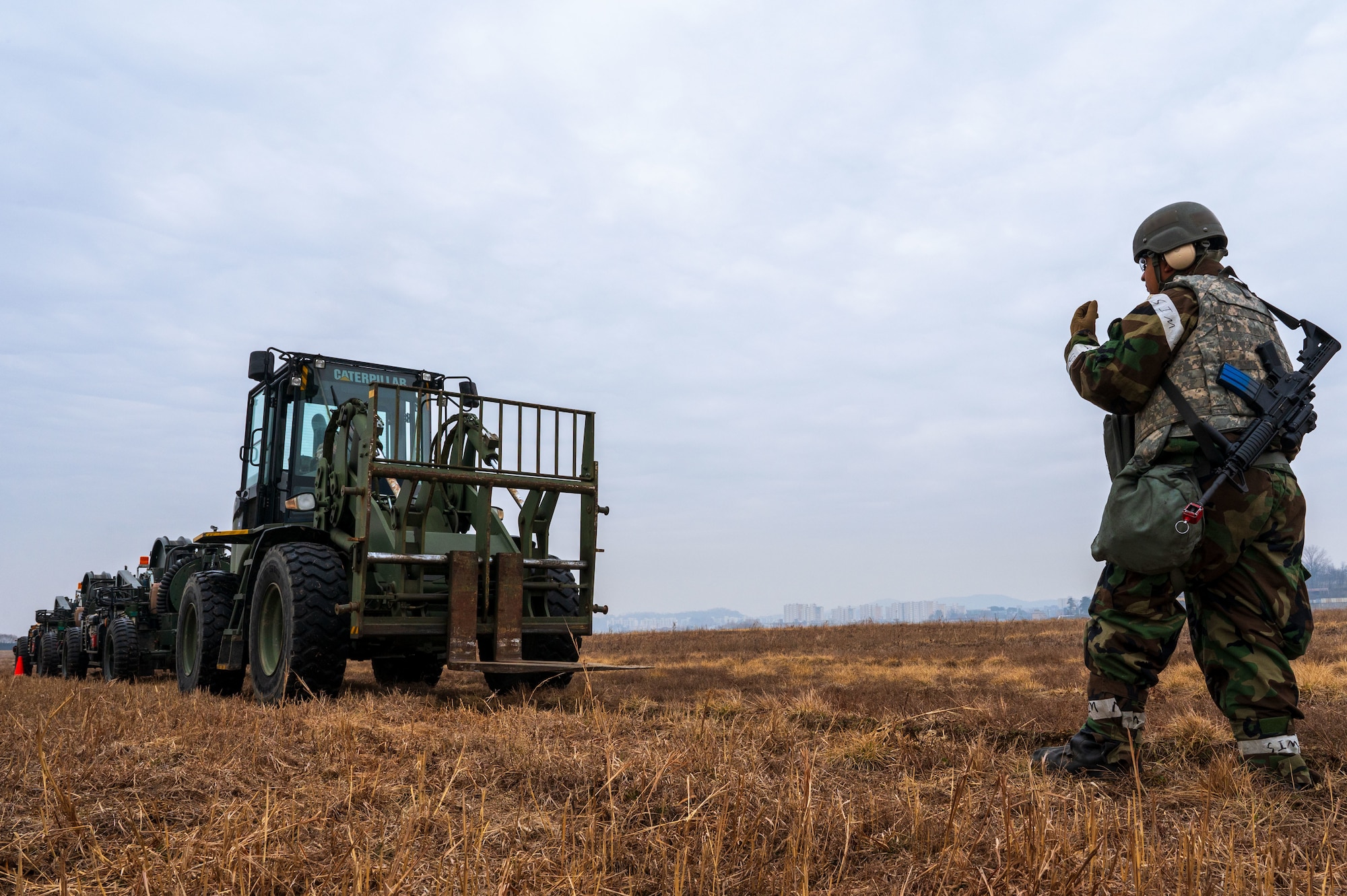 A U.S. Airman assigned to the 51st Fighter Wing guides a vehicle towing an aircraft arresting system into position at Osan Air Base, South Korea, March 12, 2025. During Freedom Shield 25, Airmen from the 11th ATF partnered with 51st FW personnel to gain certification in AAS procedures through hands-on training. (U.S. Air Force photo by Senior Airman Jasmyne Bridgers-Matos)