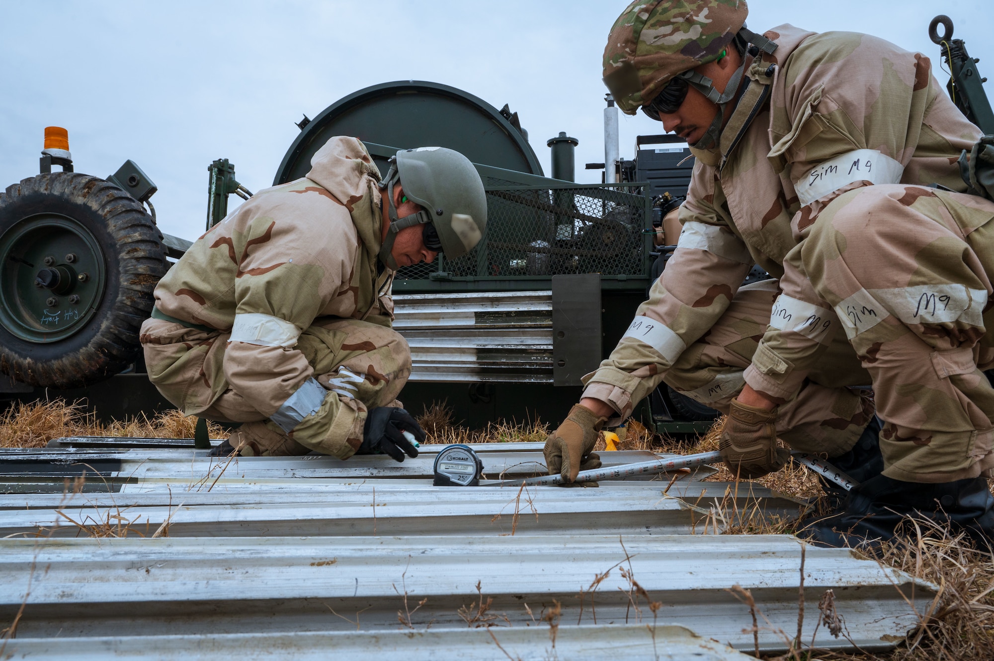 U.S. Airmen assigned to the 11th Air Task Force measure and mark the stakes for an aircraft arresting system during Freedom Shield 25 at Osan Air Base, South Korea, March 12, 2025. Stakes were used to anchor the system and provide a secure foundation for the arresting cables or barriers, allowing them to safely stop or slow down an aircraft. (U.S. Air Force photo by Senior Airman Jasmyne Bridgers-Matos)