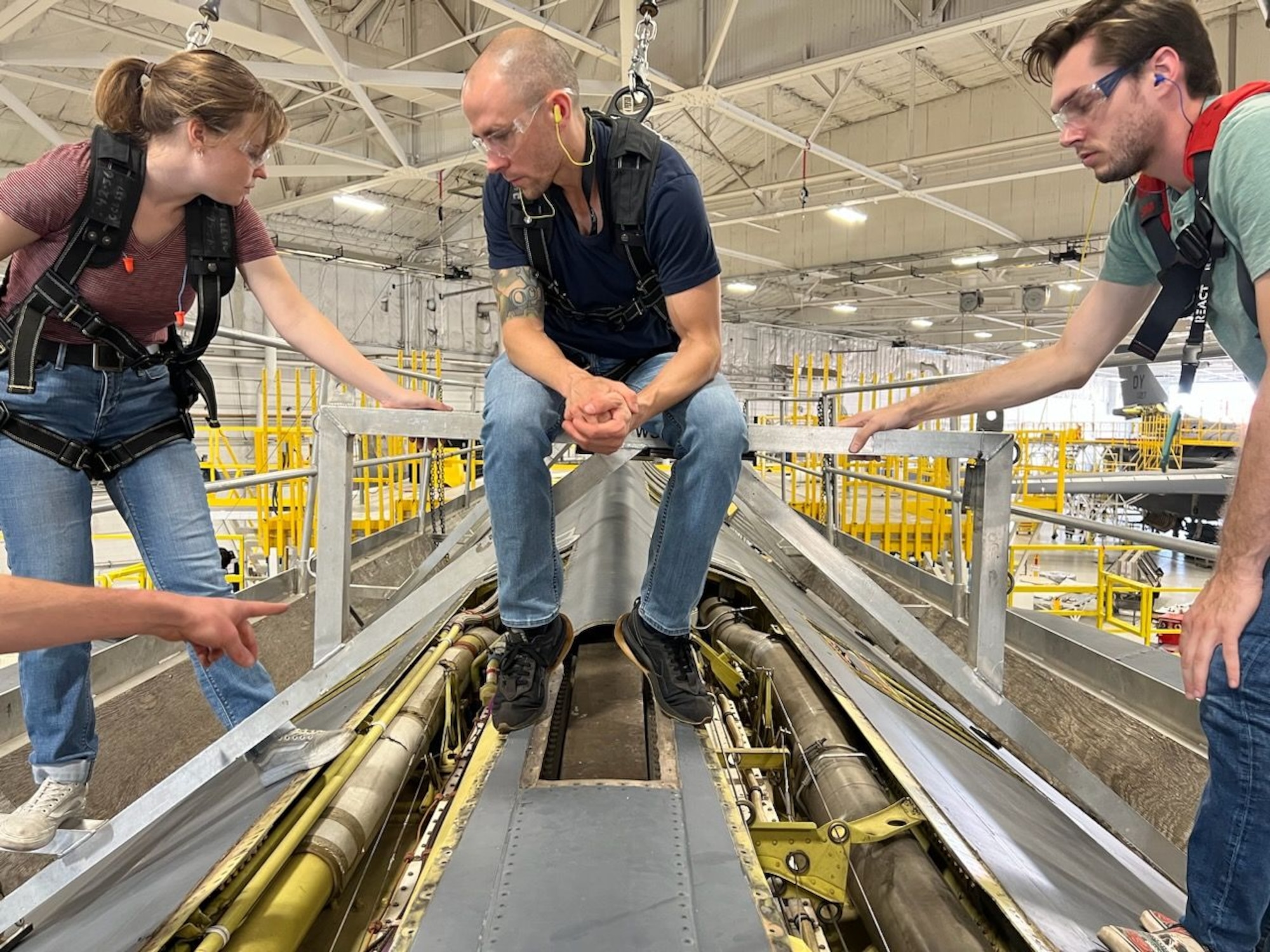Three engineers atop a B1 aircraft.