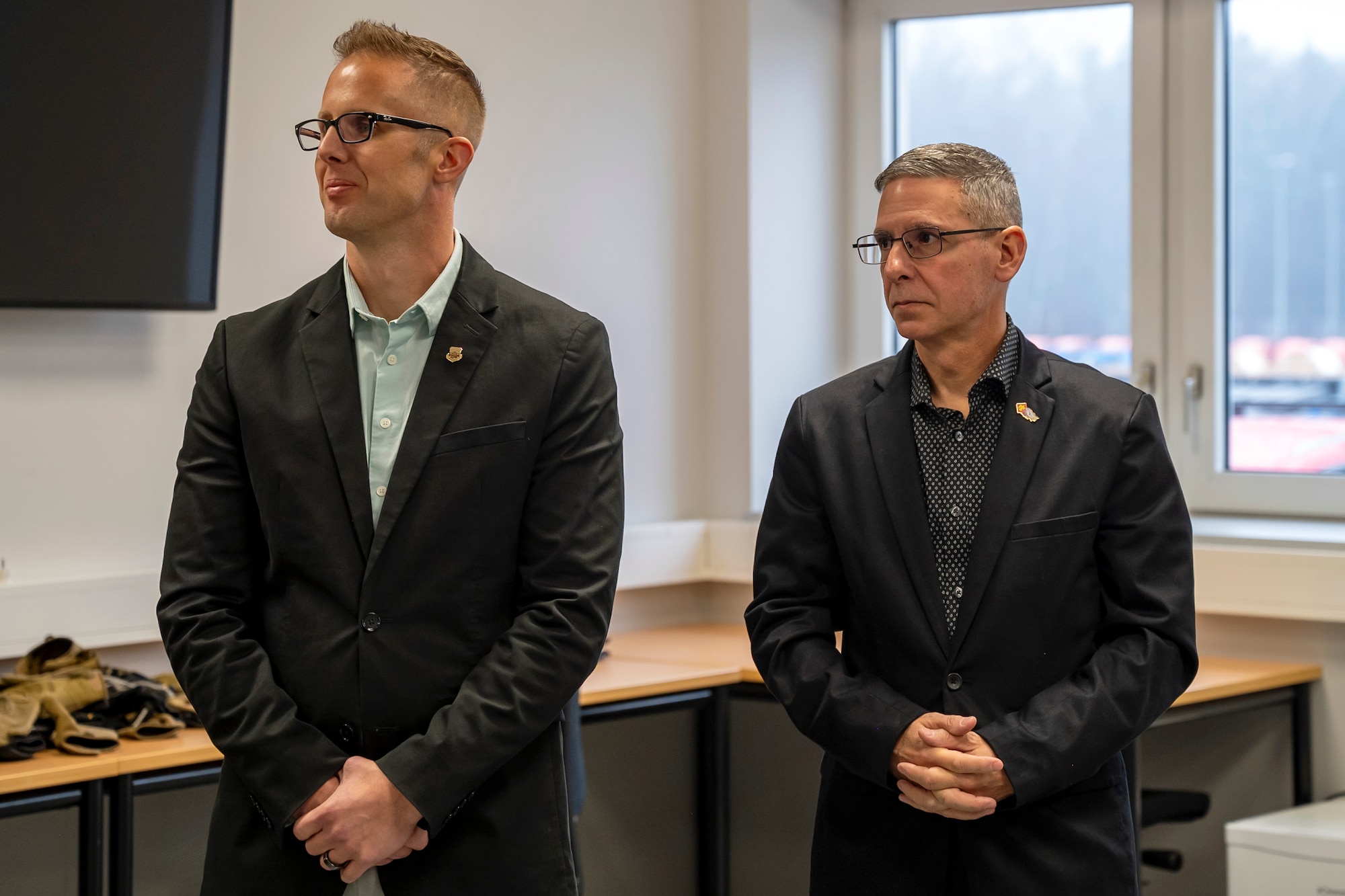 U.S. Air Force Chief Master Sgt. Joshua Wiener, Ninth Air Force (Air Forces Central) command chief, left, and Chief Master Sgt. Dennis DiPiazzo, state command chief, Oklahoma Air National Guard, listen to a briefing during a tour of the facilities at the Inter-European Air Forces Academy (IEAFA) at Kapaun Air Station, Germany, Feb. 12, 2025.