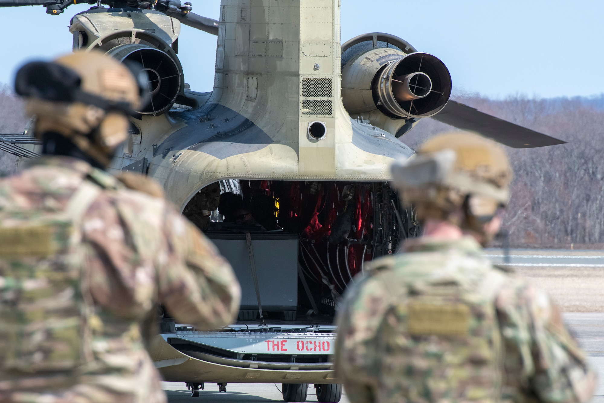Two men look at helicopter.