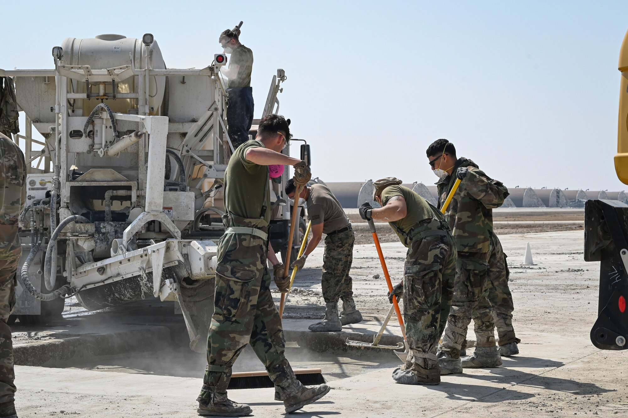 U.S. Marine Corps combat engineers with Marine Wing Support Squadron 172, Marine Aircraft Group 36, 1st Marine Aircraft Wing, smooth out layers of concrete in a Rapid Airfield Damage Recovery after a simulated attack during Freedom Shield 25 at Kunsan Air Base, Republic of Korea.