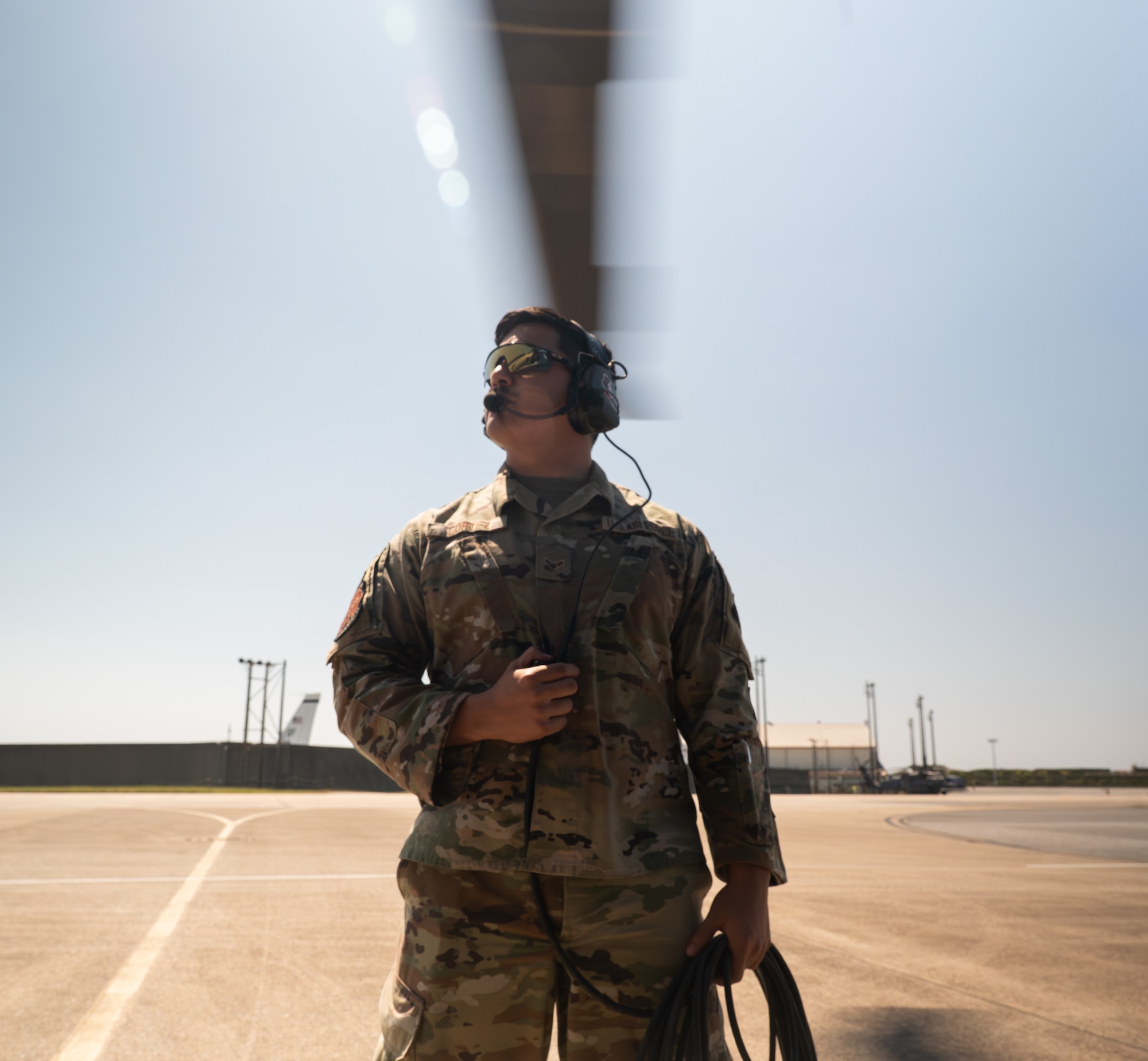 a U.S. service member stands outside a HH-60W Jolly Green II.