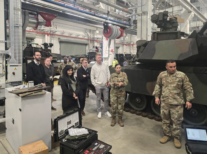 Chief Warrant Officer 4 Juan Santibanez, the senior maintenance warrant officer with Army Field Support Battalion-Poland, (right) briefs professional staff members from the House Armed Services Committee at the Powidz Army Prepositioned Stocks-2 worksite in Powidz, Poland, March 20. (Capt. James Bath)