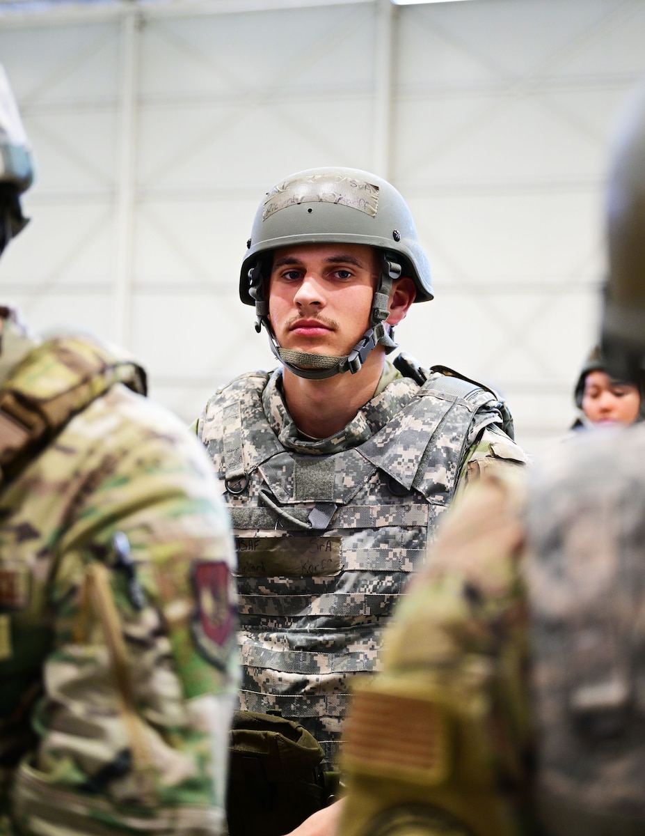 Exercise deployer sits among peers waiting to be briefed.