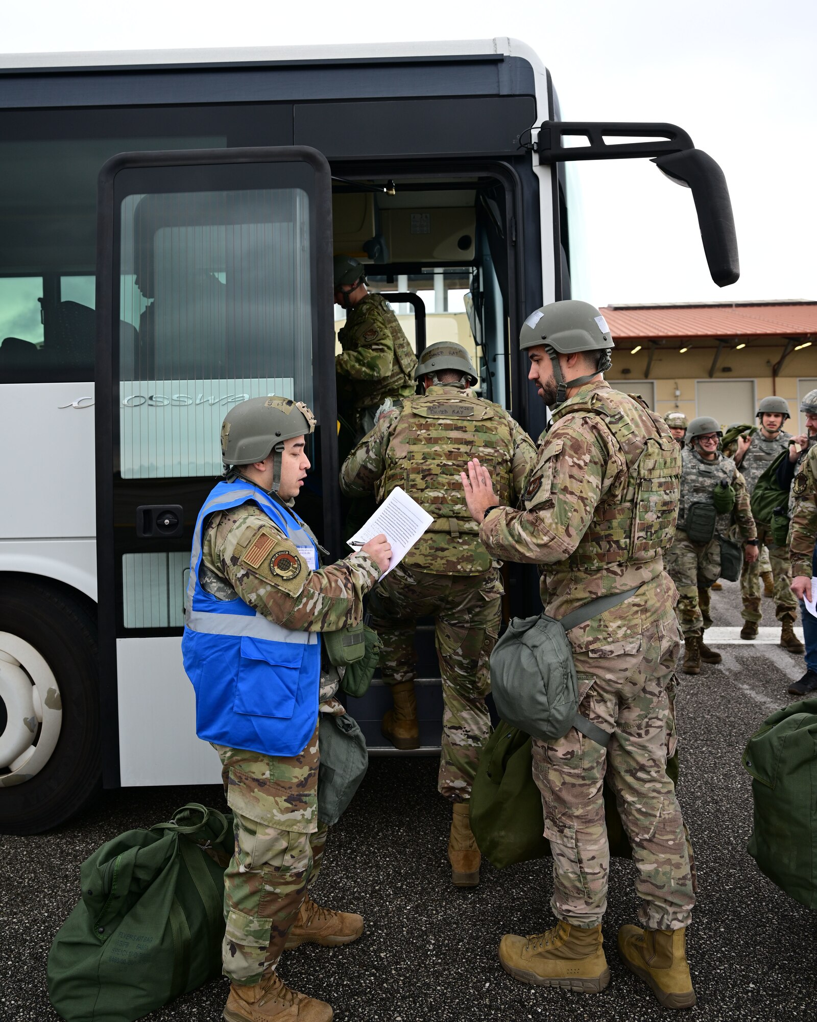 U.S. Airmen pile onto a bus during a mock deployment.
