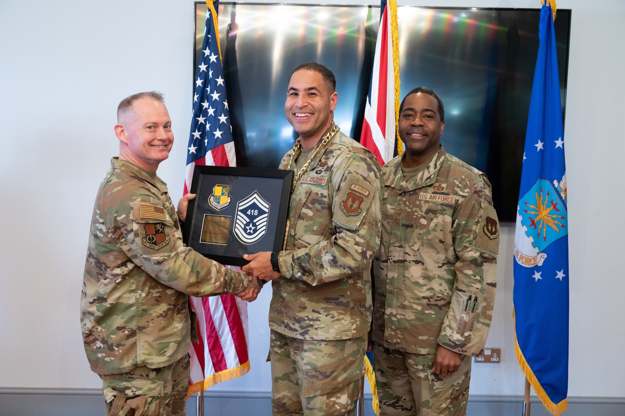 U.S. Air Force Col. D. Landon Phillips, 501st Combat Support Wing (CSW) commander, and Chief Master Sgt. Terrance D. Boyd, 501st CSW command chief, presents a promotion plaque to a Pathfinder