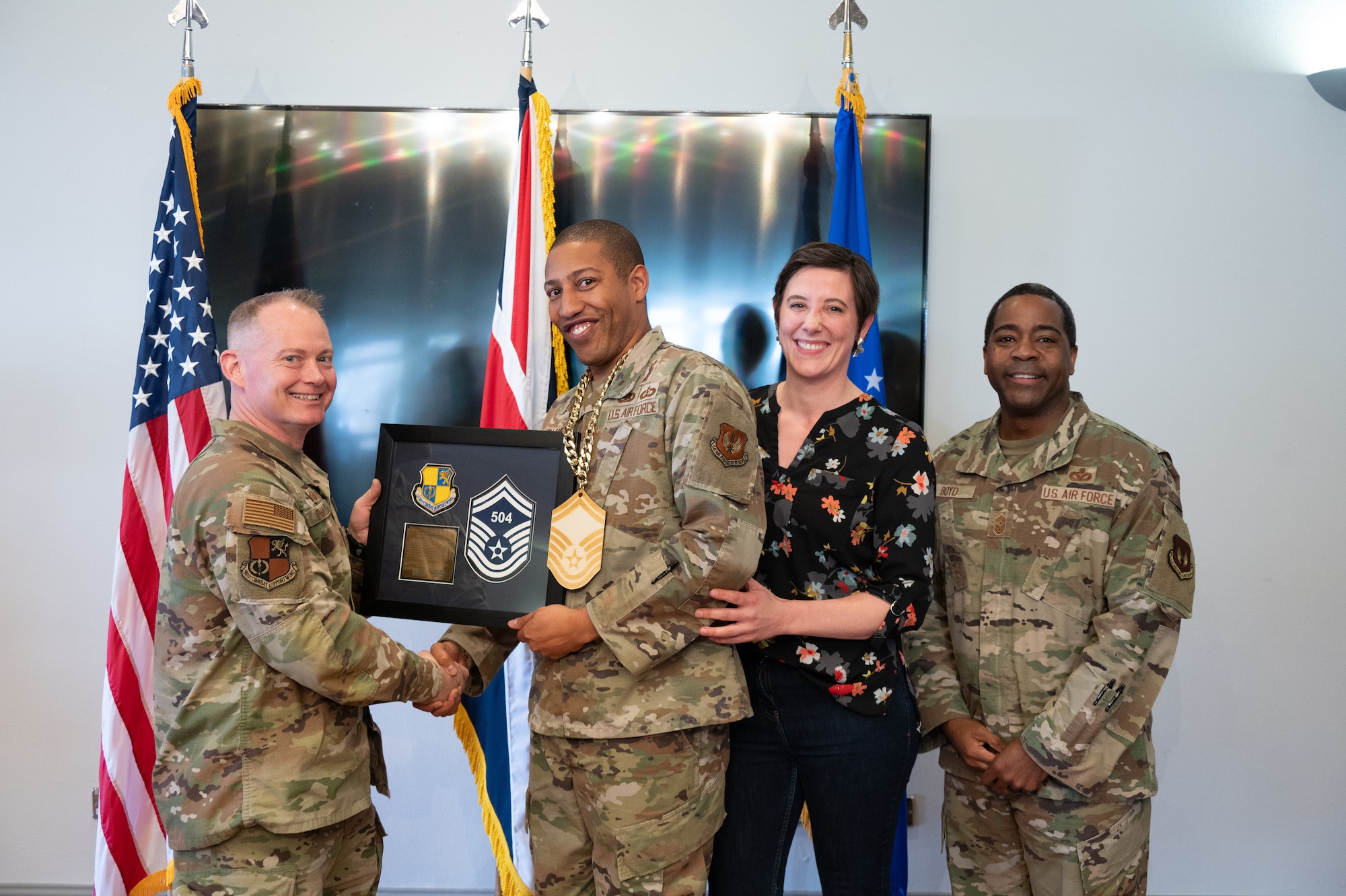 U.S. Air Force Col. D. Landon Phillips, 501st Combat Support Wing (CSW) commander, and Chief Master Sgt. Terrance D. Boyd, 501st CSW command chief, presents a promotion plaque to a Pathfinder