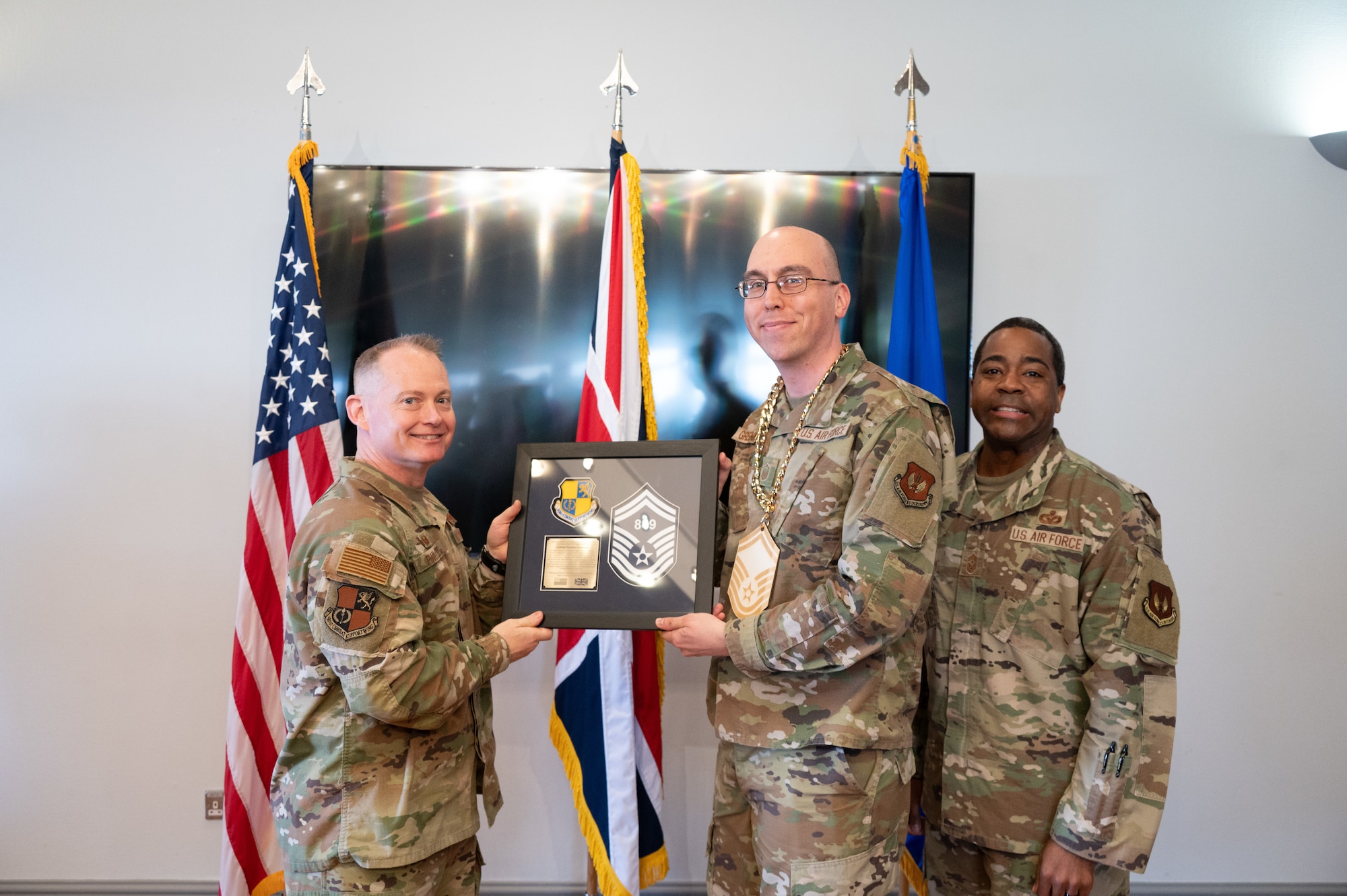 U.S. Air Force Col. D. Landon Phillips, 501st Combat Support Wing (CSW) commander, and Chief Master Sgt. Terrance D. Boyd, 501st CSW command chief, presents a promotion
