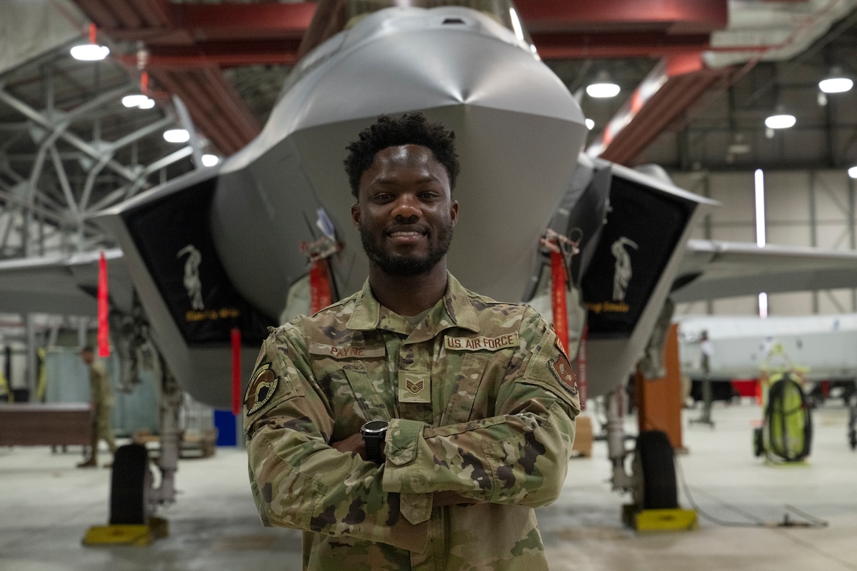 Staff Sgt. Payne poses in front of an F-35 Lightning II aircraft.