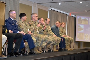 Group of chaplains sitting on stage, one talking
