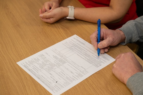 Hands hold a pen to sign a contract.