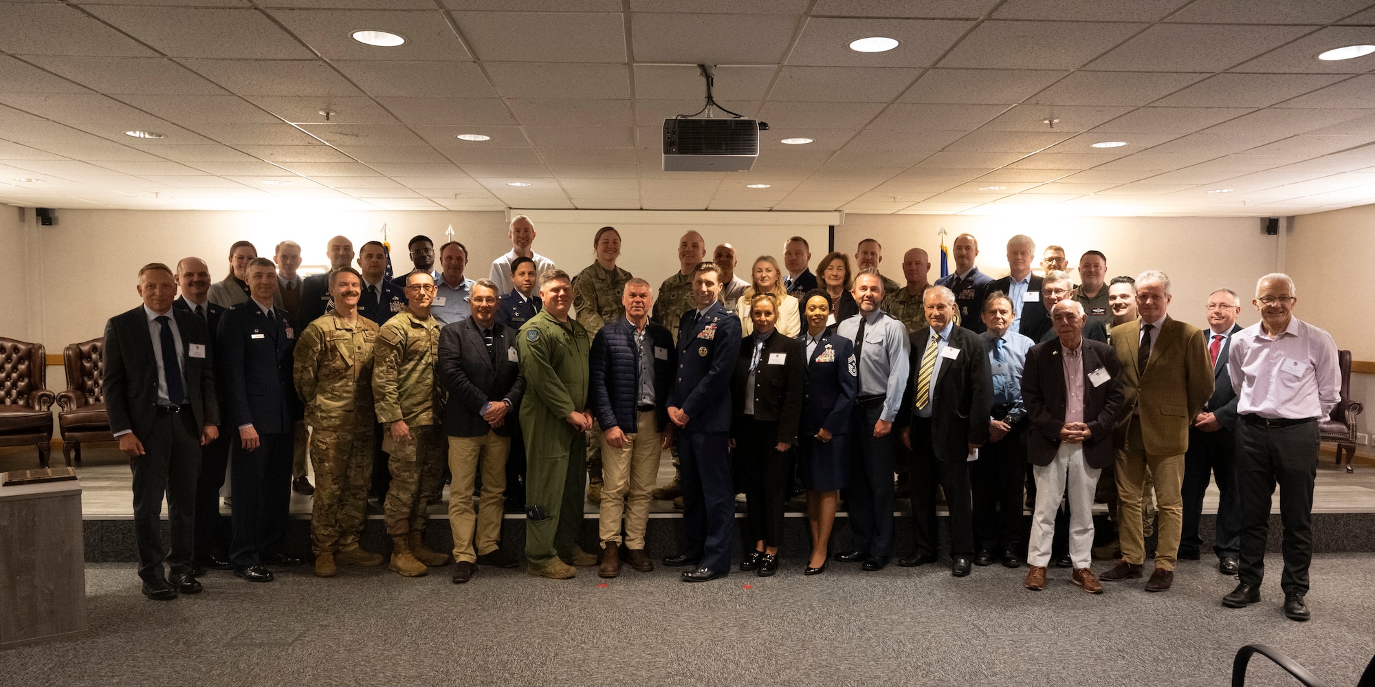 A group photo of honorary commanders, RAF Mildenhall leadership, and family members during the honorary commanders’ induction ceremony at RAF Mildenhall, England, March 21, 2025.