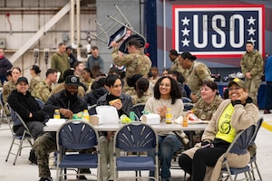 Team Dover Airmen and families sit at tables to eat while listening to the Mission Ready Rally opening remarks at Dover Air Force Base.