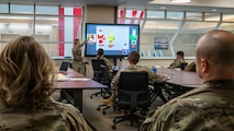 A 5th Medical Group clinical team chief gives a presentation about mass casualty procedures to a room full of Airmen.