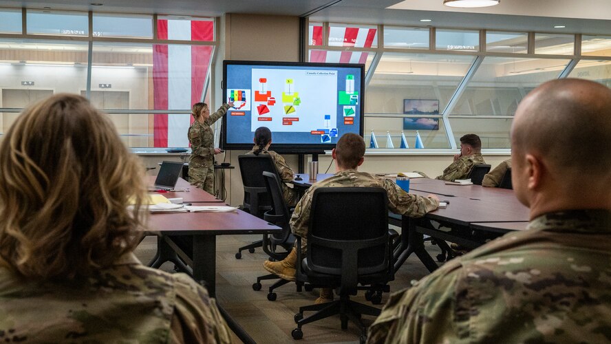 A 5th Medical Group clinical team chief gives a presentation about mass casualty procedures to a room full of Airmen.