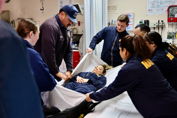 Hospital corpsmen assigned to the Multi-Service Unit at Naval Hospital Twentynine Palms participate in Tactical Combat Casualty Care (TCCC) training alongside the Marine Corps Air Ground Combat Center Fire Department on March 21. The hands-on exercise reinforced critical trauma response skills, ensuring corpsmen are prepared to provide life-saving care in mass casualty and combat scenarios (U.S. Navy photo by Christopher C. Jones, NHTP/NMRTC Twentynine Palms public affairs officer).