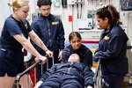 Hospital corpsmen assigned to the Multi-Service Unit at Naval Hospital Twentynine Palms participate in Tactical Combat Casualty Care (TCCC) training alongside the Marine Corps Air Ground Combat Center Fire Department on March 21. The hands-on exercise reinforced critical trauma response skills, ensuring corpsmen are prepared to provide life-saving care in mass casualty and combat scenarios (U.S. Navy photo by Christopher C. Jones, NHTP/NMRTC Twentynine Palms public affairs officer).