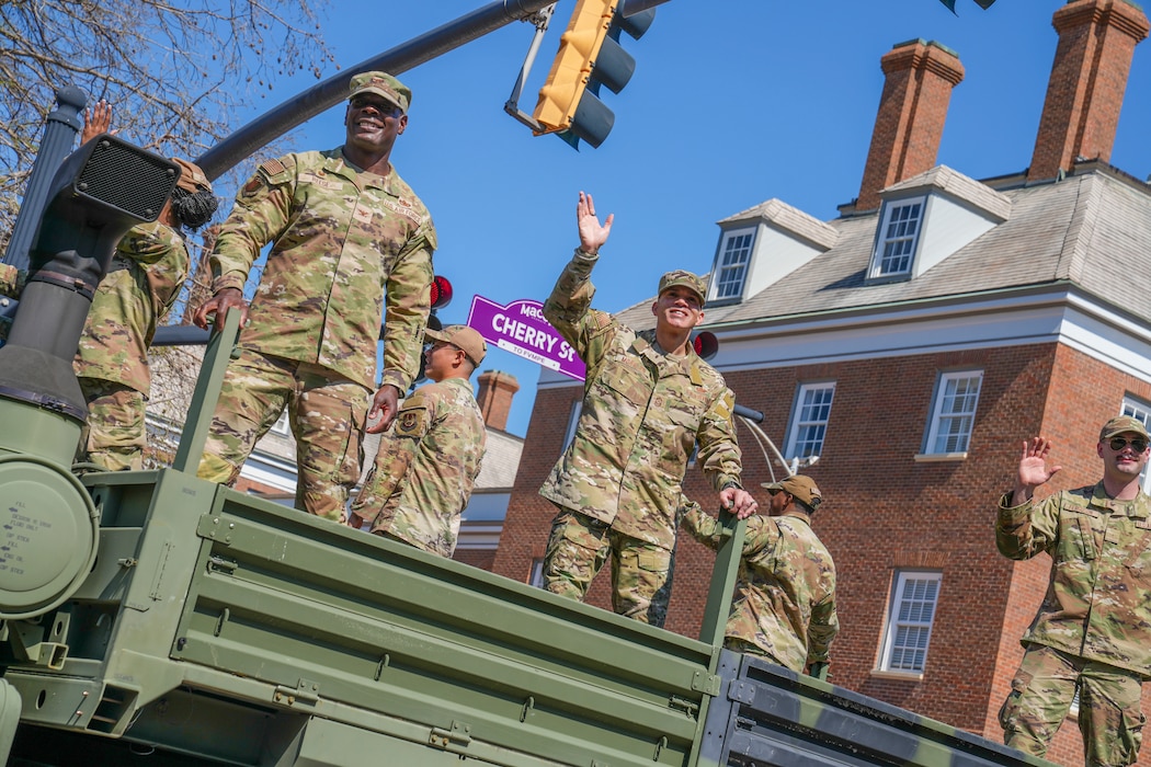 Uniformed Service Members waving from Military Vehicle