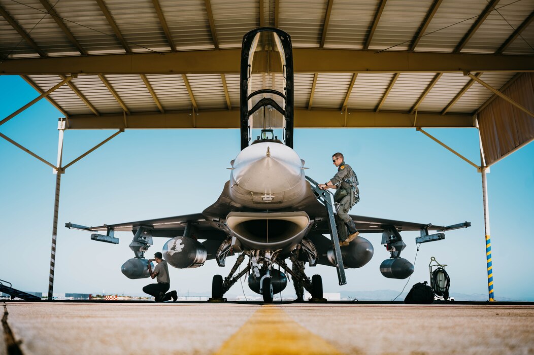 U.S. Air Force Lt. Col. Michael Ress, 309th Fighter Squadron commander, climbs into the cockpit of an F-16 Fighting Falcon.