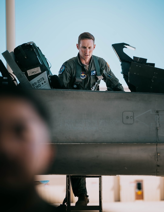 U.S. Air Force Lt. Col. Michael Ress, 309th Fighter Squadron commander, climbs into the cockpit of an F-16 Fighting Falcon.