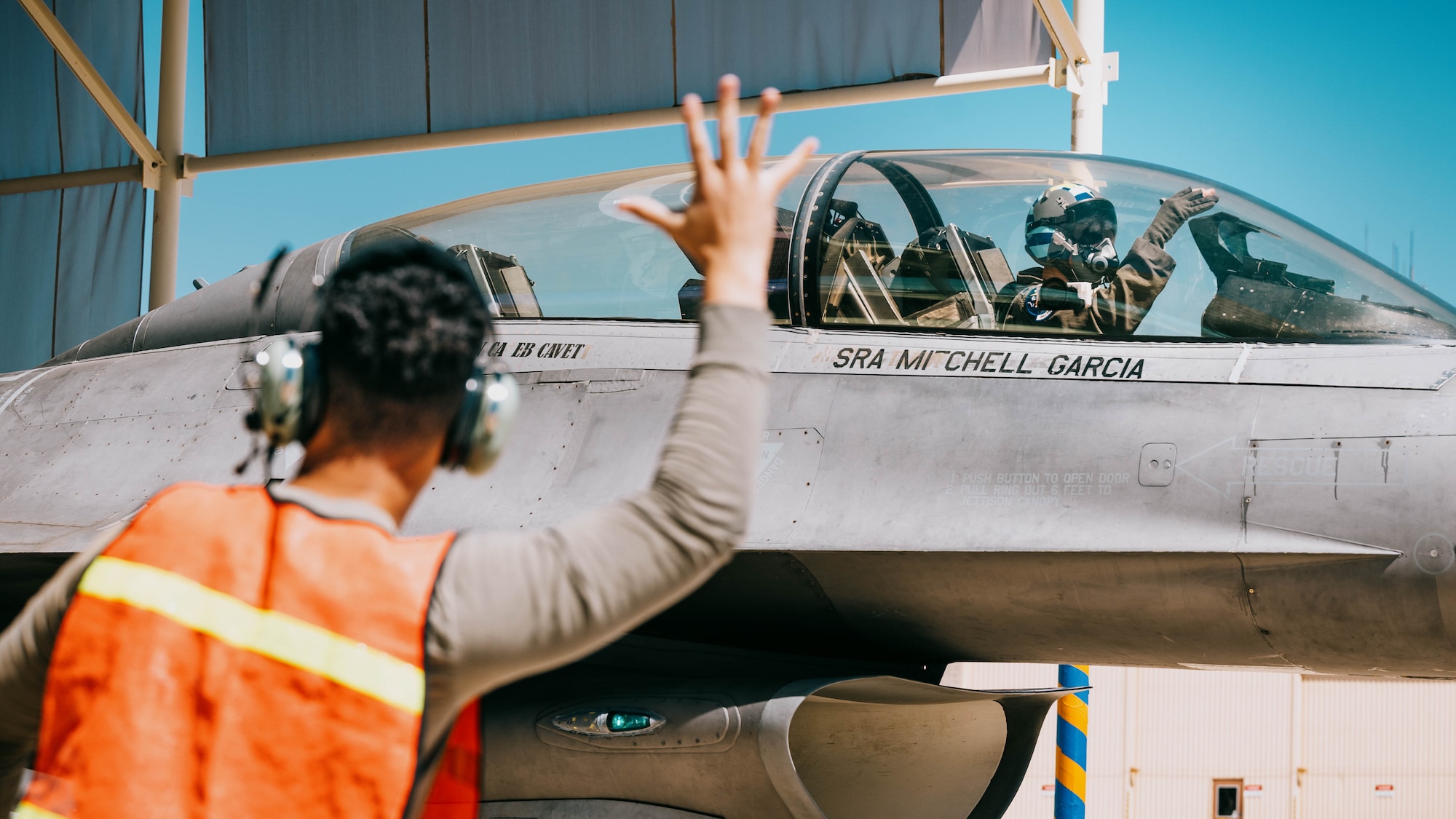 U.S. Air Force Lt. Col. Michael Ress, 309th Fighter Squadron commander, signals farewell in the cockpit of a U.S. F-16 Fighting Falcon.