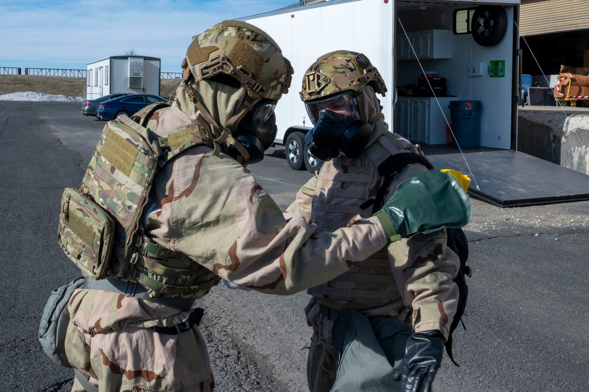 U.S. Air Force Airman 1st Class Michael Antonellis and Airman 1st Class Kenneth Armstead, emergency management specialists assigned to the 92nd Civil Engineer Squadron, begin dry decontamination procedures using a charcoal mitt during training at Fairchild Air Force Base, Washington, Feb. 22, 2025. The M295 kit is a packet that contains an activated carbon and alumina-silicate powder inside of a hook and loop-cinched mitt that soaks up chemical contamination like a sponge. (U.S. Air Force photo by Airman 1st Class Samantha Thorn)