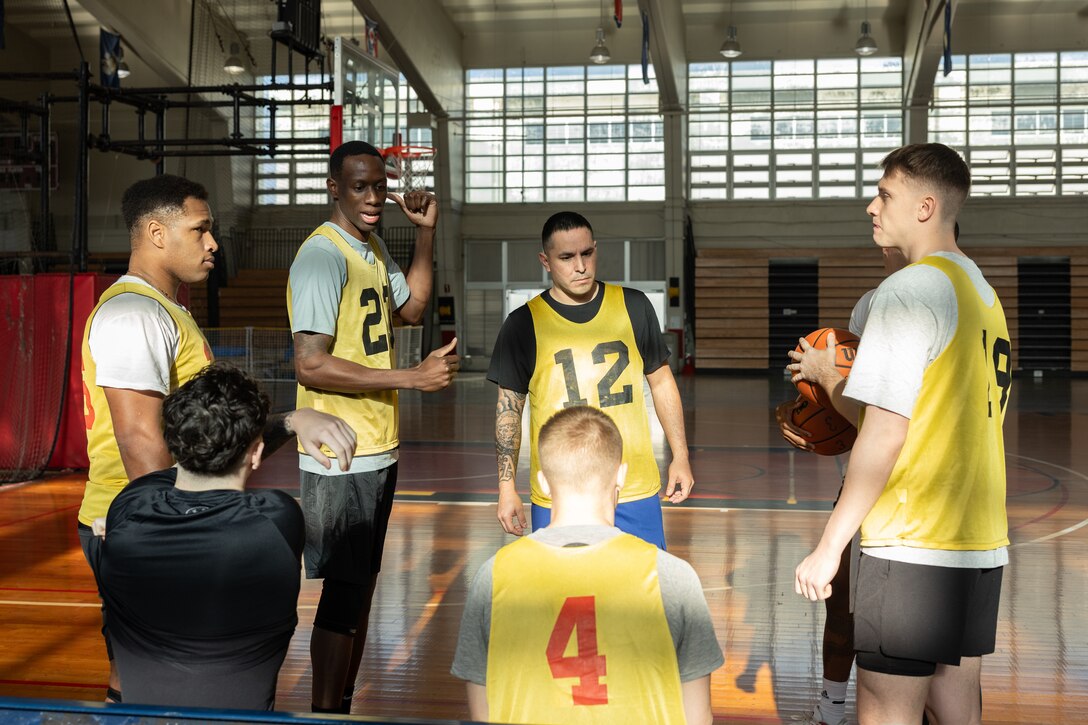 U.S. Marines with Marine Corps Installations Pacific Marine Corps Base Butler Postal hold a team meeting during the Pacific Iron Challenge on Camp Foster, Okinawa, Japan, March 20, 2025. The Pacific Iron Challenge is a series of events where different sections compete against each other in various activities. In this event Marines competed in a March Madness basketball game. (U.S. Marine Corps photo by Cpl. Jesse Davis)