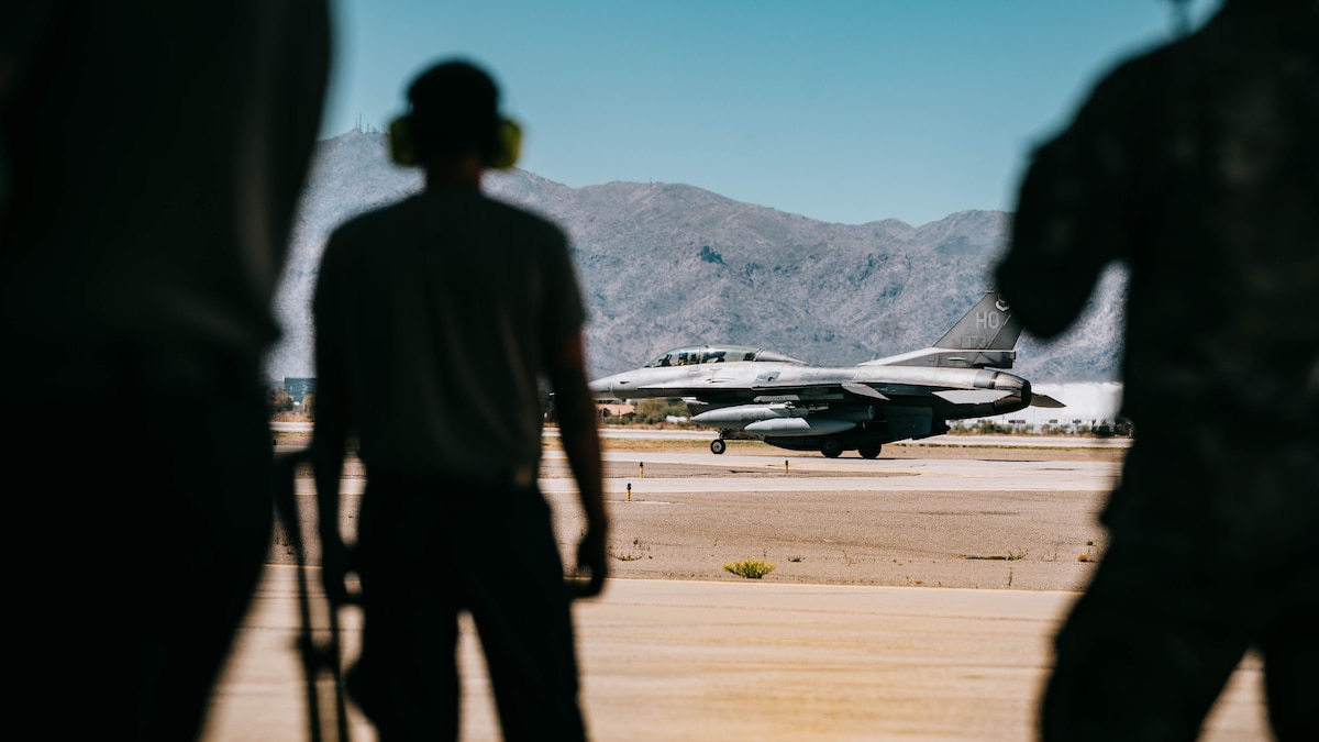 U.S. Air Force 56th Fighter Wing Airmen watch the final U.S. F-16 taxis to the runway.