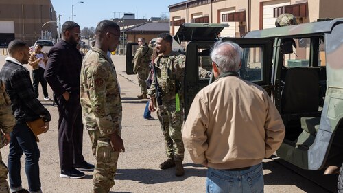 Group of men talking in front of Humvee